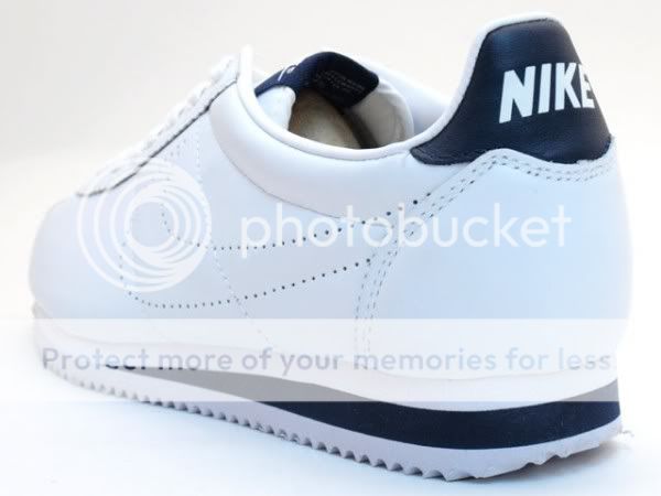 white and navy blue nike cortez